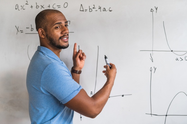 male teacher teaching math lesson to high schoolers